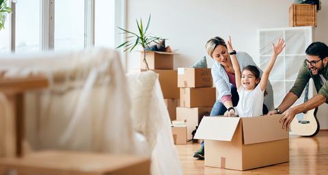 hero image of a joyful family with boxes in a new home